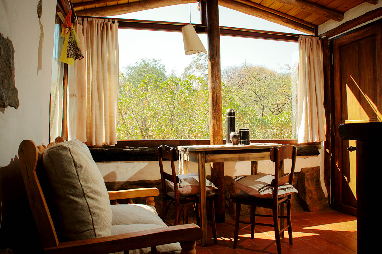 Interior de cabaña con vista al monte